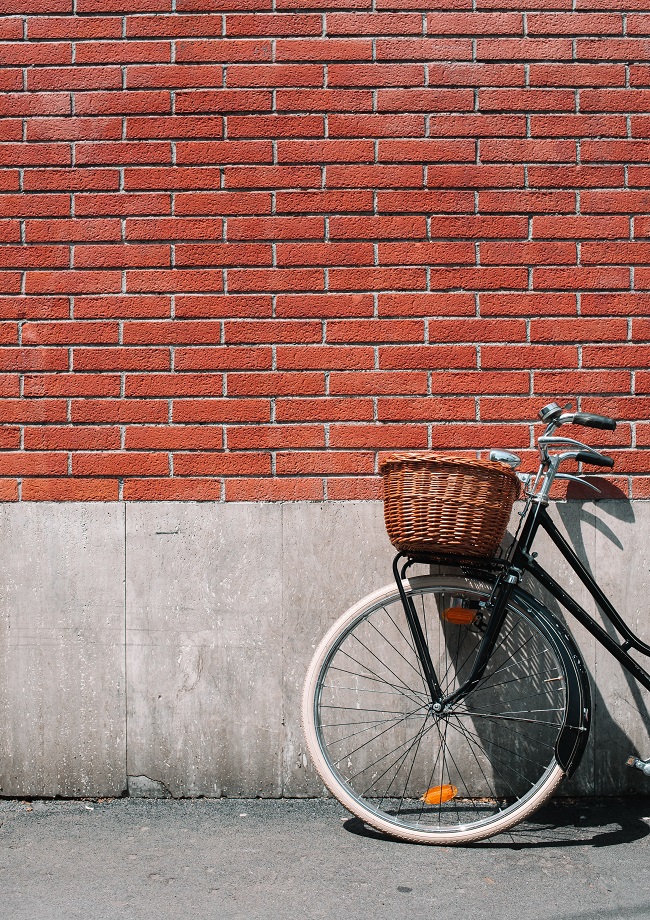 un vélo devant un mur de briques rouges