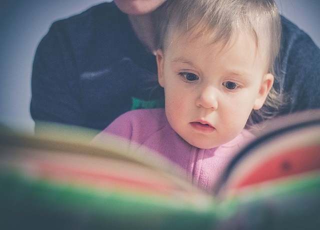 un bébé qui regarde un livre