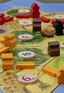 des pions de couleurs et des jetons numérotés sur un plateau de jeu
