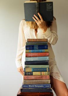une femme derrière une pile de livres