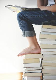 un enfant assis sur une pile de livres