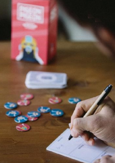 un main notant le score avec la boîte de jeu en arrière plan