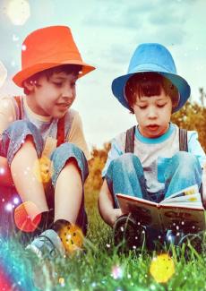 photos de deux enfants lisant un livre dans l'herbe