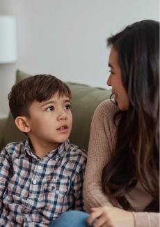 photo d'un garçon qui discute avec une adulte sur un canapé
