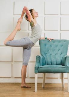 femme faisant du yoga à côté d'un fauteuil