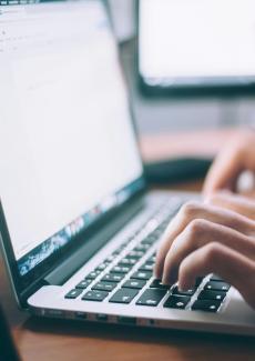 photo d'une personne tapant au clavier d'un ordinateur portable